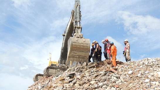 Pala Excavadora, inicia excavación para posterior sepultamiento completo de persona protegida por una estructura hermetizable ( XXXVI Curso Internacional Método Arcón )